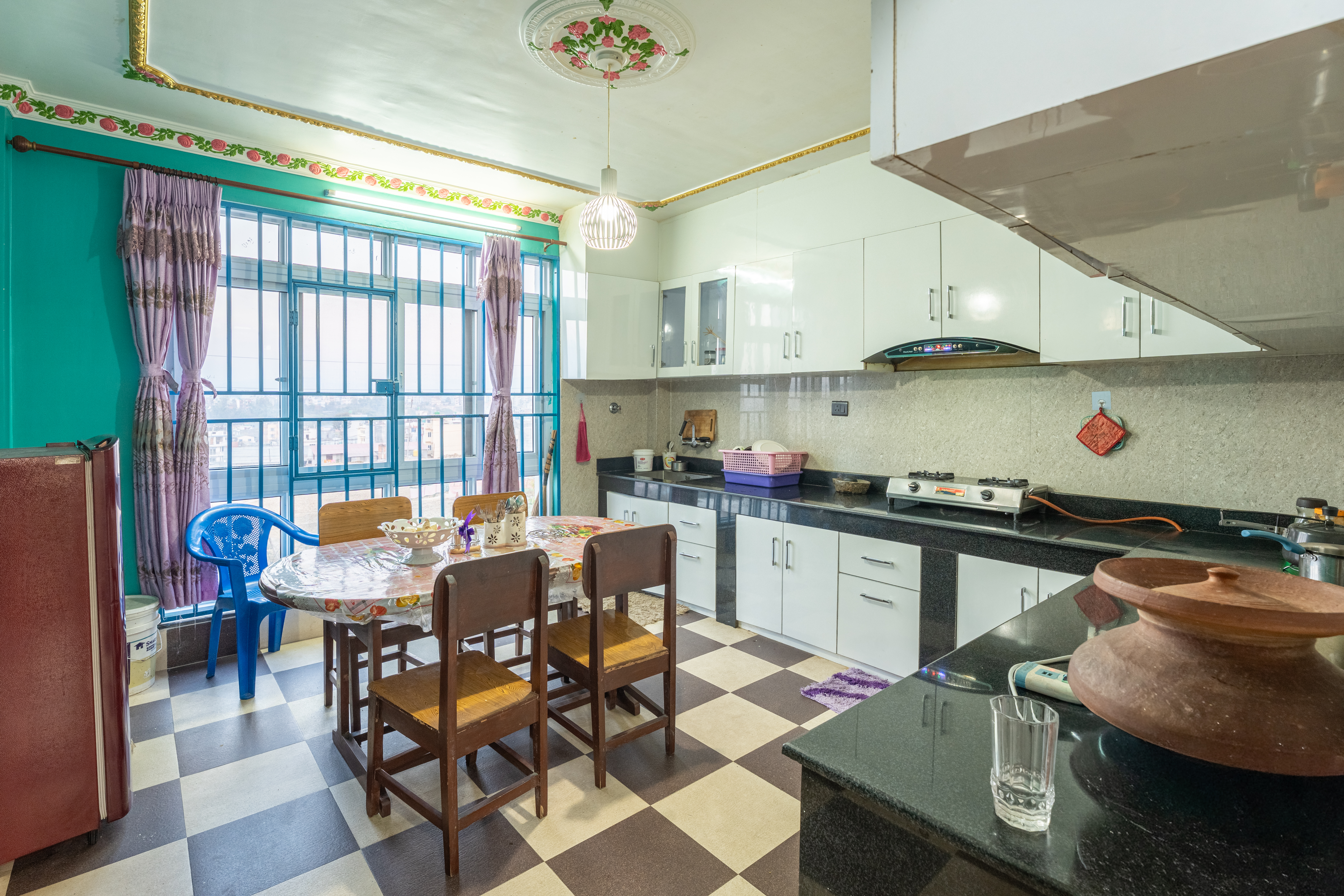 Shared kitchen and dining area with modern appliances at Aananda Homestay